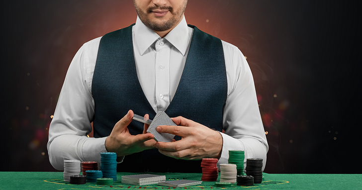 A Picture of A Man Wearing a White Shirt and Black Vest Holding Online Casino Chips